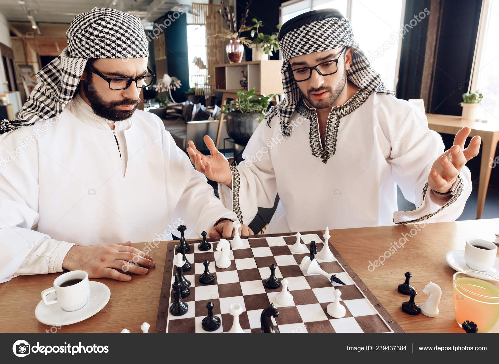 One arab businessman checkmates another playing chess at table at